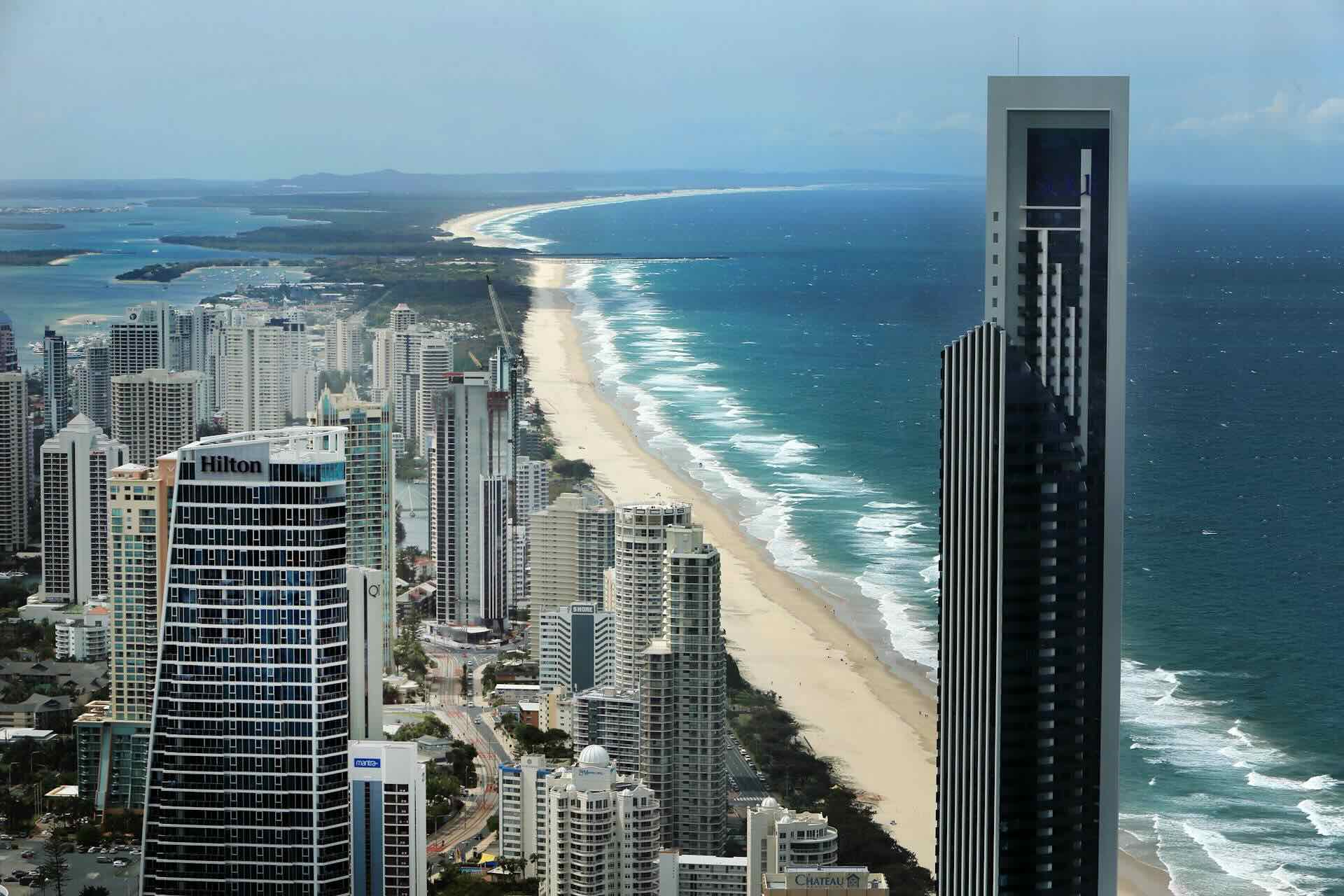 Aerial view of the Goldcoast with long beach stretching out and waves crashing the beach.